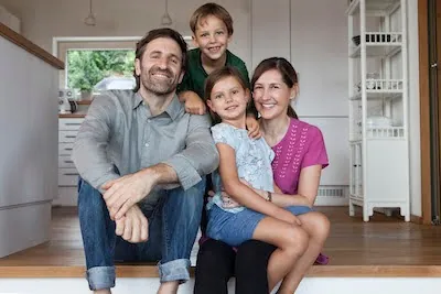 family sitting on the floor in their home after a Fort Myers pest control service.