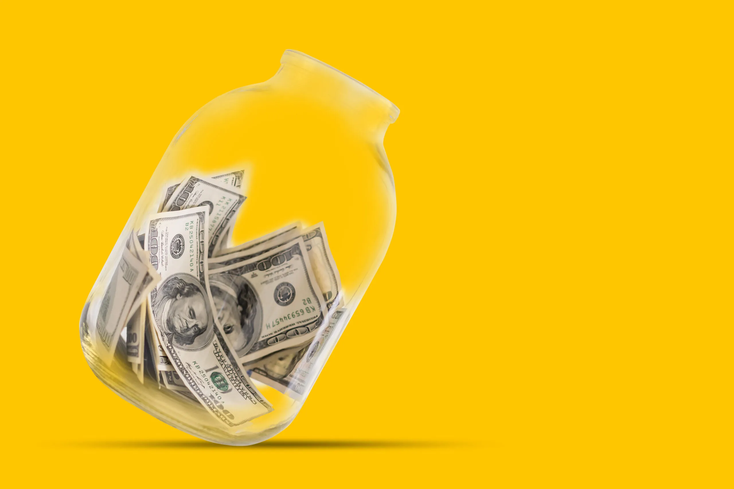 Many 100 US dollars bank notes in a glass jar isolated on yellow background save $50 on recurring services image